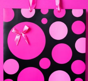 Black friday sale concept. Top view of pink paper shopping bag on trendy bright background. Copy